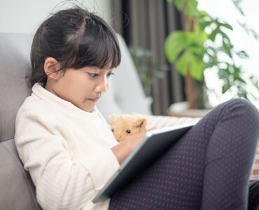 Малко момиче с таблет играе онлайн - Пази детето в Интернет