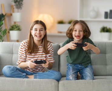 Две деца, играещи на видеоигри