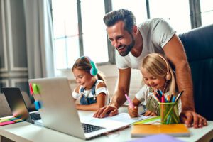 Две деца учат онлайн у дома и получават помощ и надзор на родител